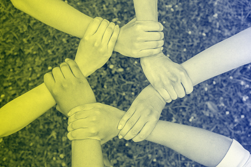 Entrecroisement de mains de personnes différentes